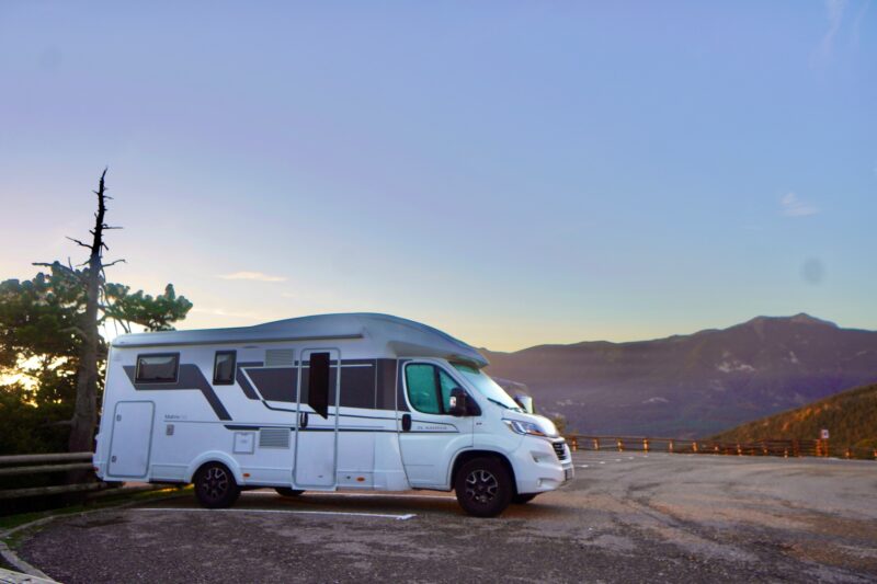 White motorhome parked in campsite overlooking mountain